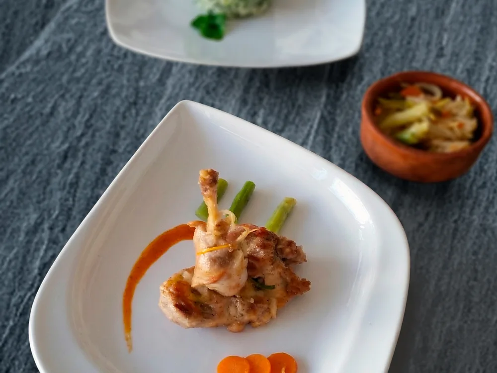 Plato de pollo con verduras fotografiado sobre piedra oscura